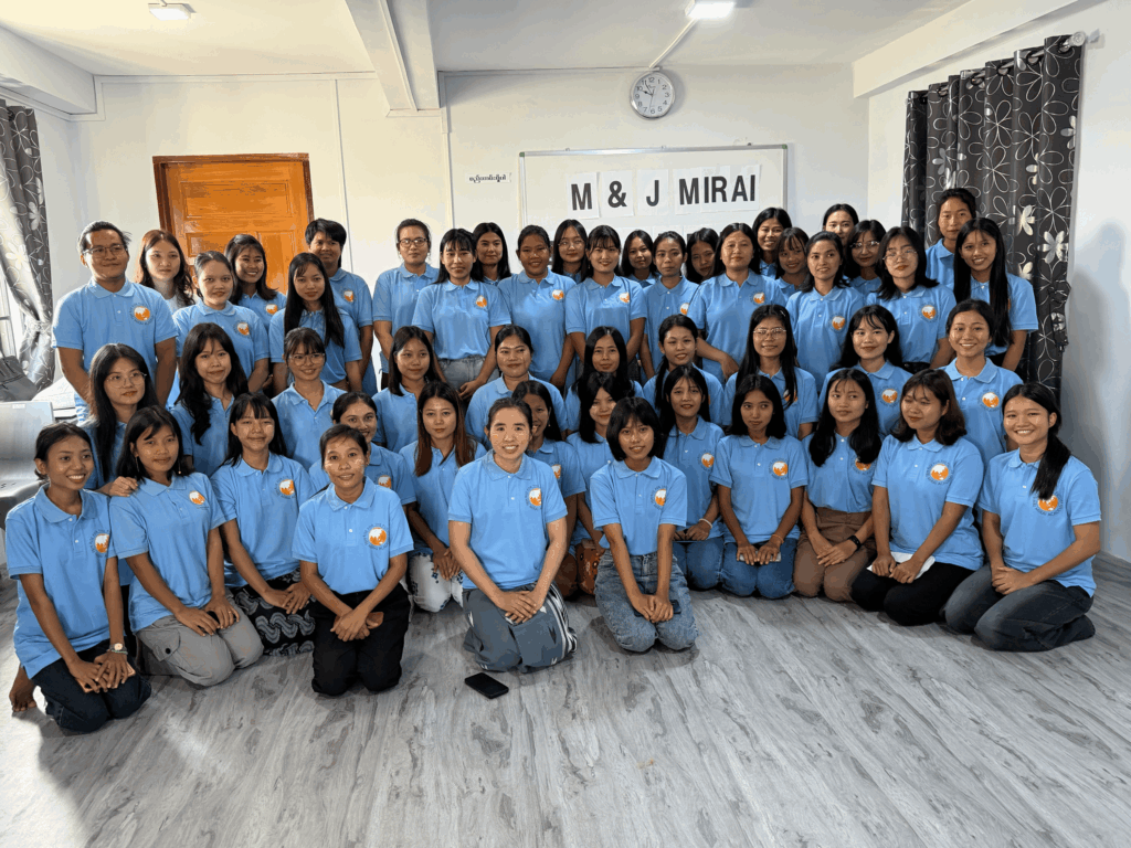 ミャンマーにあるMIRAI日本語学校で、MIRAIクラスに在籍する約45名の学生が教室に集まり、集合写真を撮影している様子